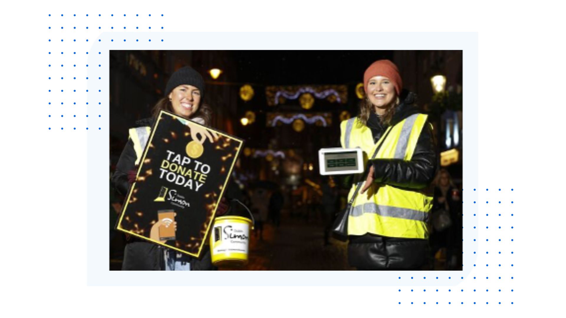 Charity collectors using portable handheld donation terminals on a city street at night